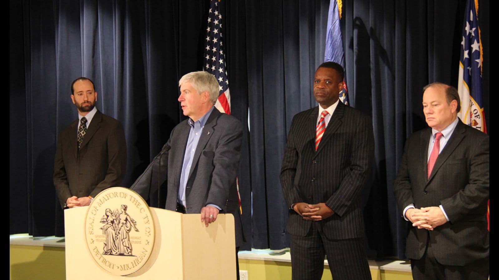 Michigan Governor Rick Snyder announces end to the Detroit bankruptcy proceedings on December 10, 2014, with City Councilman Gabe Leland, outgoing Emergency Manager Kevyn Orr and Mayor Mike Duggan behind him